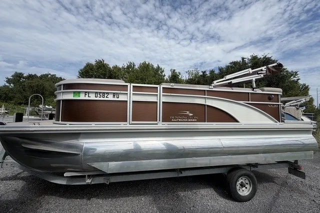 The Image of 2018 Bennington SX 20 PREMIUM pontoon boat on trailer, parked outdoors. - 0