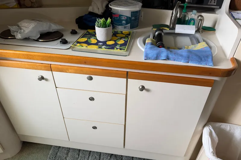 Slide: The Image of Compact kitchen area in a 1995 Cruisers Yachts 3570 Esprit, featuring a sink and stove. - 32