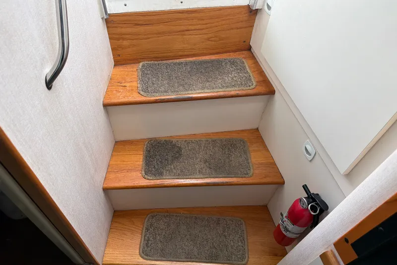 Slide: The Image of Staircase inside 1995 Cruisers Yachts 3570 Esprit with carpeted steps and fire extinguisher. - 31
