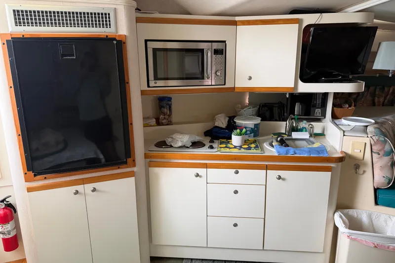 Slide: The Image of 1995 Cruisers Yachts 3570 Esprit interior kitchen with microwave, sink, and cabinets. - 37