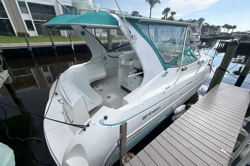 Slide: The Image of 1995 Cruisers Yachts 3570 Esprit docked, featuring a sleek white design with teal accents. - 15