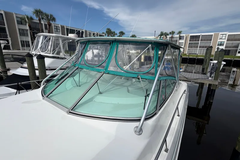 Slide: The Image of 1995 Cruisers Yachts 3570 Esprit docked, featuring green canopy and sleek design. - 19