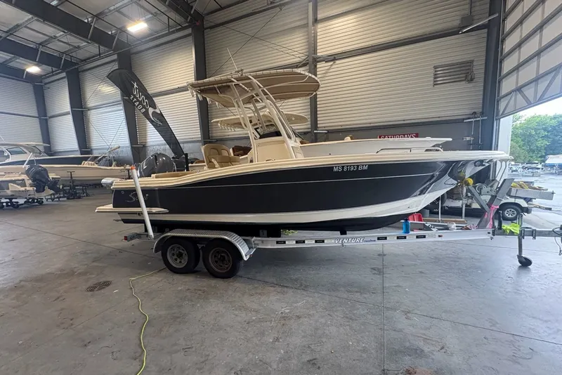 The Image of 2020 Scout 215 XSF boat on trailer in indoor storage facility. - 0
