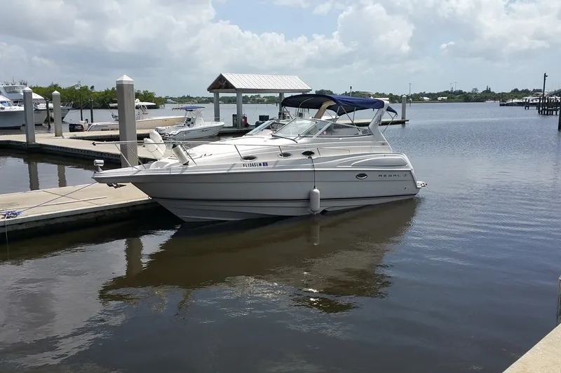 The Image of 2001 Regal Commodore 2760 boat docked at a marina under a cloudy sky. - 0