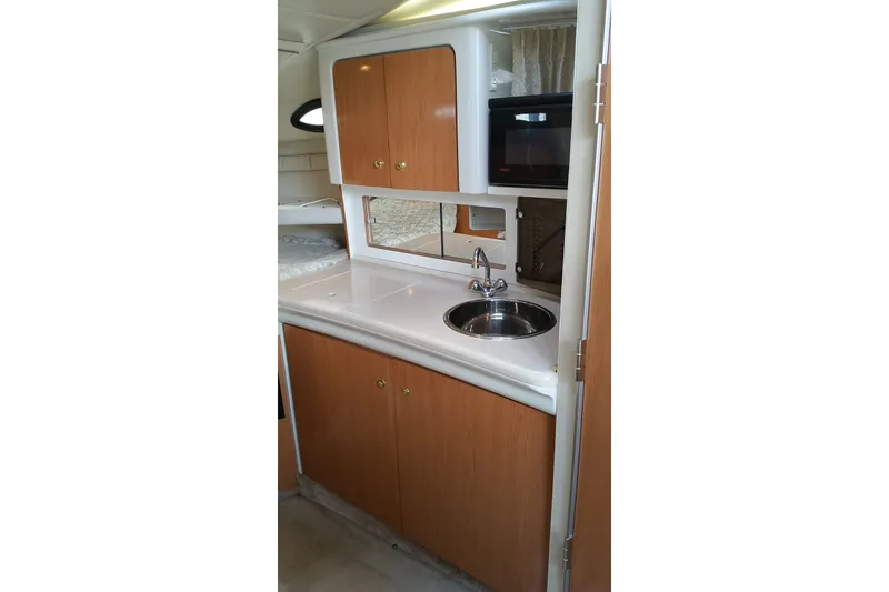 Slide: The Image of 2001 Regal Commodore 2760 boat interior kitchen with sink, cabinets, and microwave. - 19
