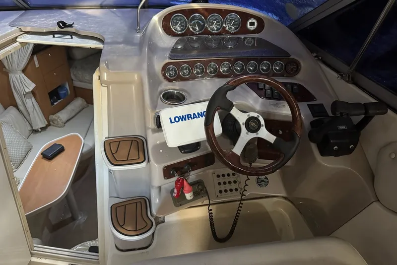 Slide: The Image of 2001 Regal Commodore 2760 boat cockpit with steering wheel, gauges, and cabin view. - 13