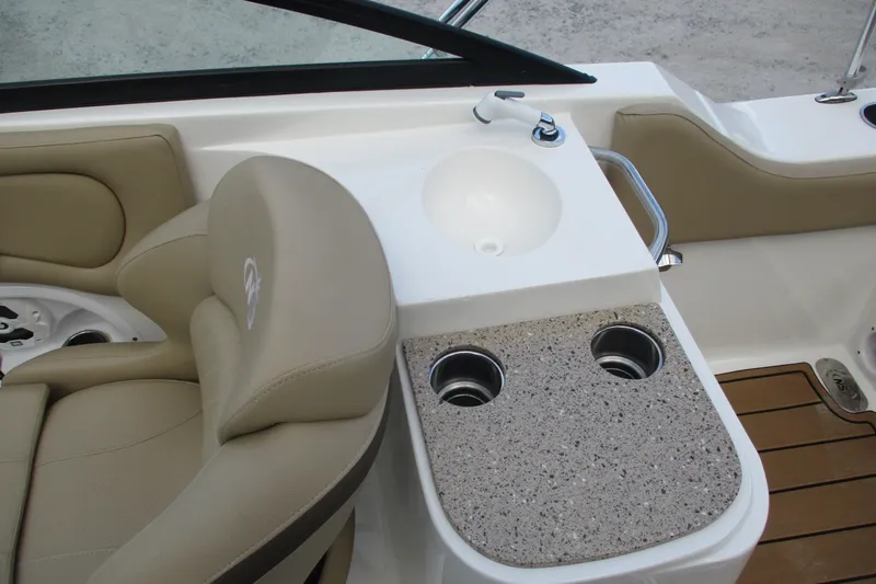 Slide: The Image of 2020 NauticStar 2302 Legacy Dual Console interior with beige seating and sink area. - 15