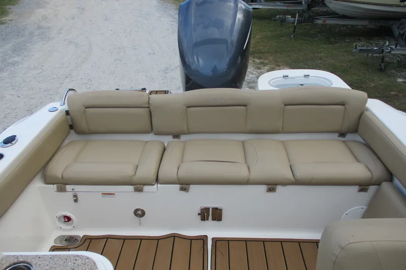 Slide: The Image of 2020 NauticStar 2302 Legacy Dual Console boat with beige seating and wood-style flooring. - 14