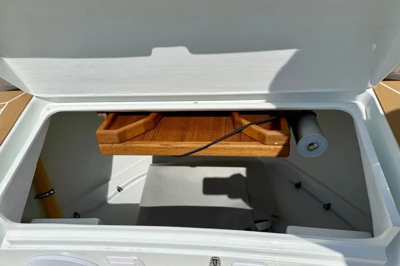 Slide: The Image of Open storage compartment in a 2027 Targa 32 boat, featuring wooden shelving. - 42