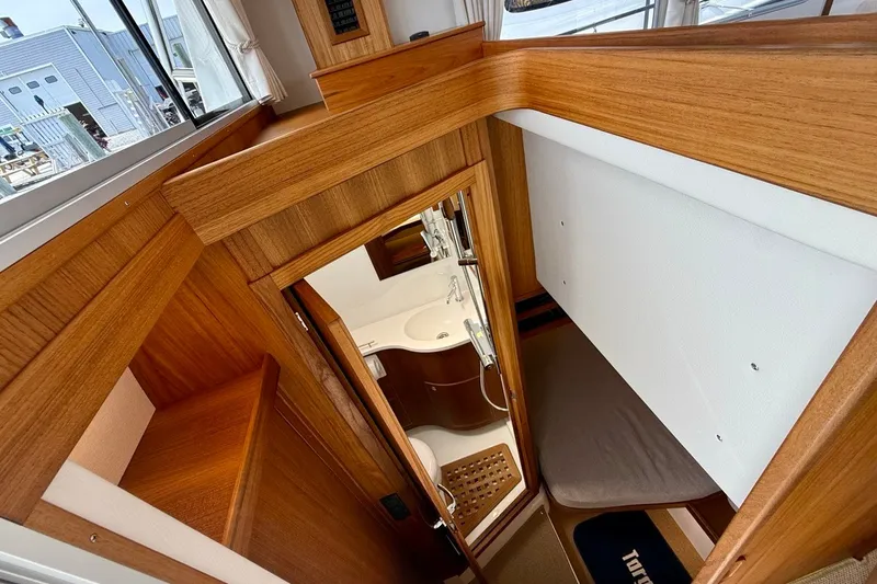 Slide: The Image of Interior of 2027 Targa 32 boat featuring wood finishes and compact bathroom. - 17