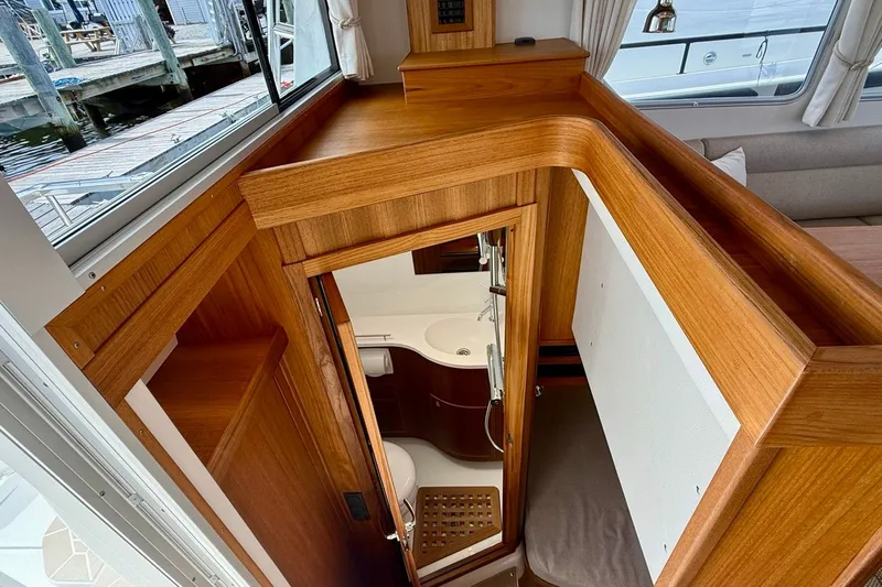 Slide: The Image of Interior of 2027 Targa 32 boat, featuring wooden cabinetry and compact bathroom. - 23
