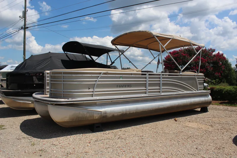 The Image of 2018 Harris Solstice 240 pontoon boat with canopy, parked on gravel under a blue sky. - 1