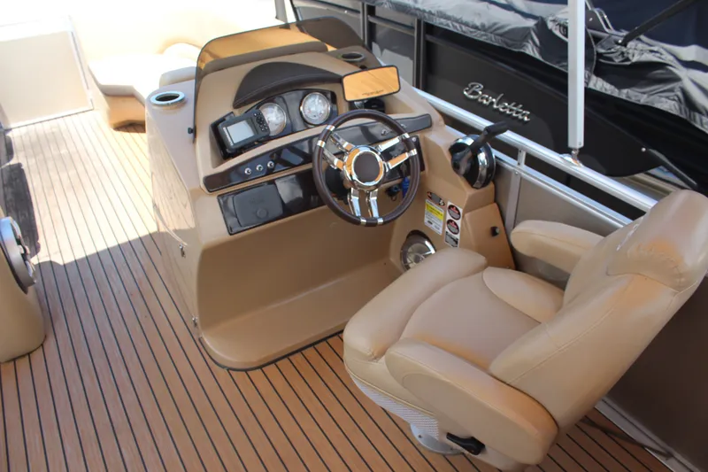Slide: The Image of 2018 Harris Solstice 240 boat helm with tan seating and modern controls. - 6