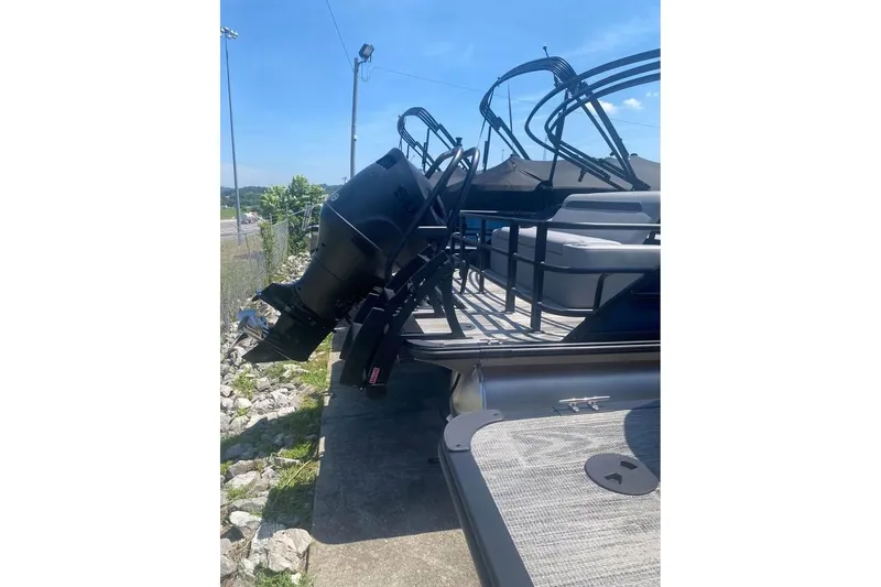 Slide: The Image of 2026 Bentley Pontoons Legacy 223 Swingback with powerful outboard motor, docked outdoors. - 15