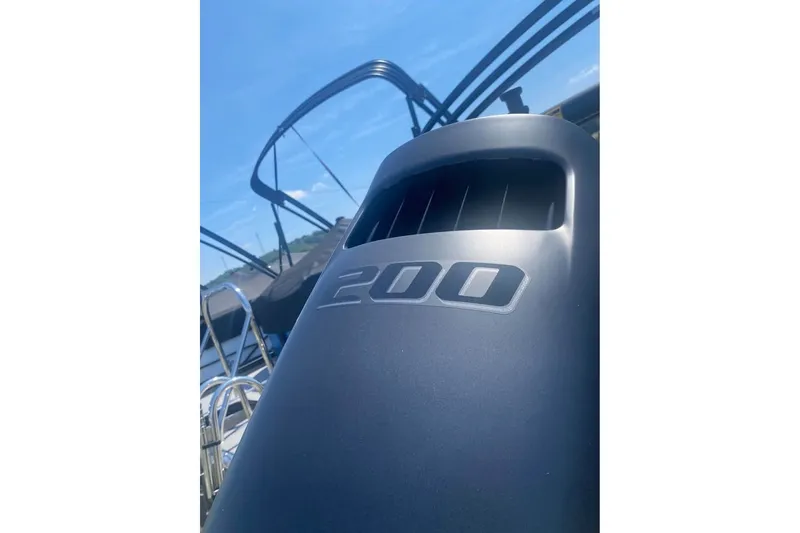 Slide: The Image of 2026 Bentley Pontoons Legacy 223 Swingback with 200 HP engine, under clear blue sky. - 13