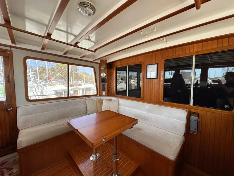 Slide: The Image of Interior of 1997 Kadey-Krogen 48 Whaleback yacht with wooden dining area and windows. - 44