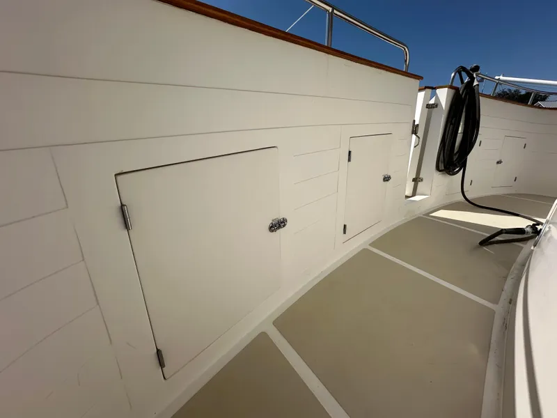 Slide: The Image of 1997 Kadey-Krogen 48 Whaleback yacht deck with storage compartments and railing. - 51