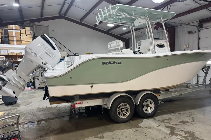 The Image of 2009 Sea Fox 256 Center Console boat on trailer in indoor storage facility. - 1