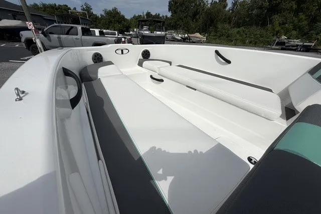 Slide: The Image of 2025 Tahoe T18 boat interior with white seating and speakers, parked outdoors. - 10