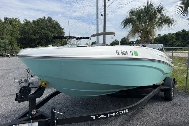 The Image of 2025 Tahoe T18 boat on trailer, light blue hull, parked outdoors. - 1