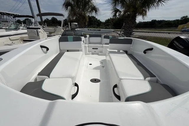 Slide: The Image of 2025 Tahoe T18 boat interior with white and gray seating, palm trees in background. - 11