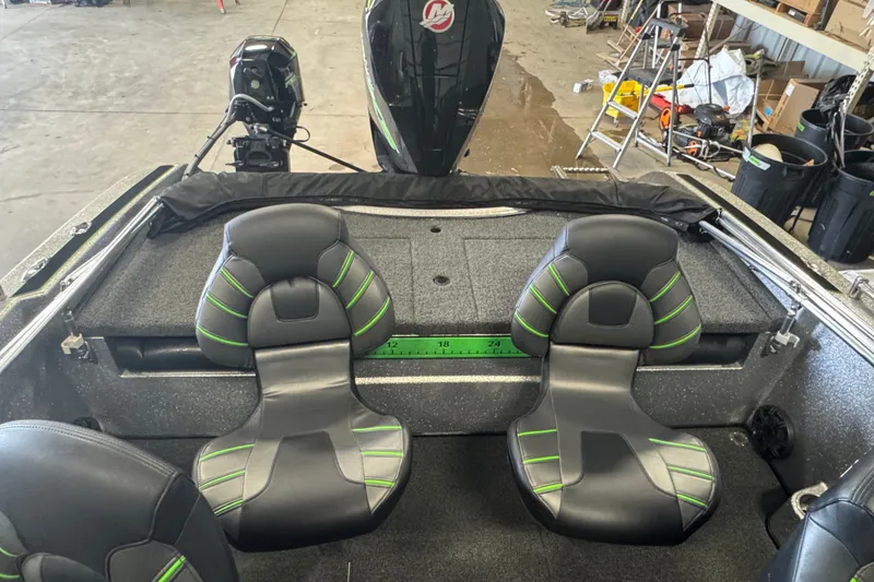 Slide: The Image of 2021 Nitro ZV19 Sport boat interior with dual seats and motor in a garage setting. - 9
