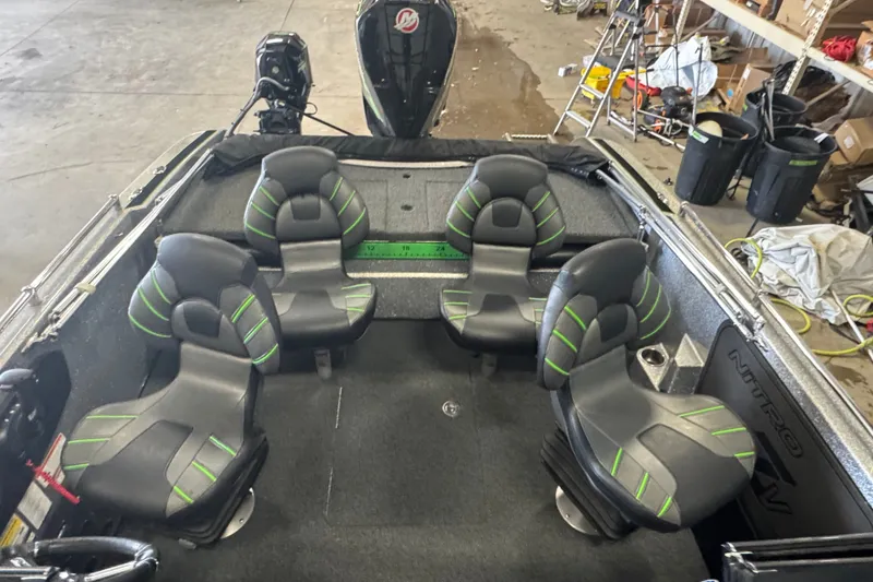 Slide: The Image of 2021 Nitro ZV19 Sport boat interior with four black and green seats in a garage setting. - 21
