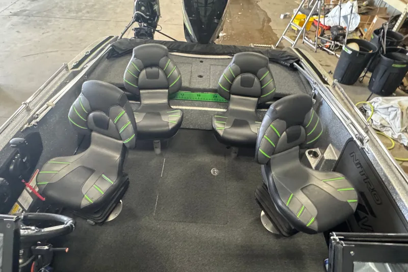 Slide: The Image of 2021 Nitro ZV19 Sport boat interior with four black and green seats in a garage setting. - 18