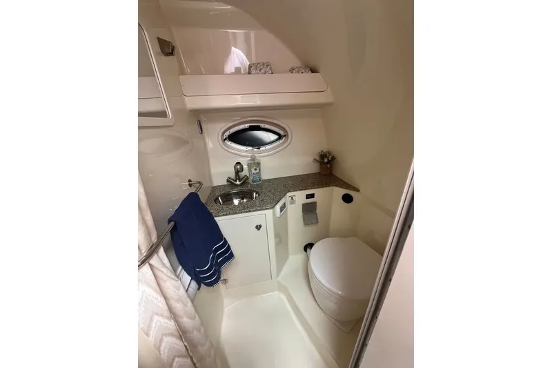 Slide: The Image of Compact bathroom in 2011 Monterey 280 SCR boat with sink, toilet, and porthole window. - 23