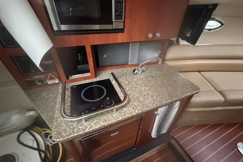 Slide: The Image of Compact kitchen area in a 2011 Monterey 280 SCR boat with stove, sink, and microwave. - 20