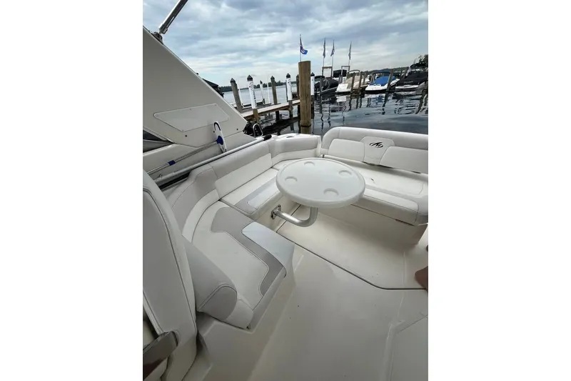 Slide: The Image of Luxurious 2011 Monterey 280 SCR boat interior with white seating and round table at marina. - 16