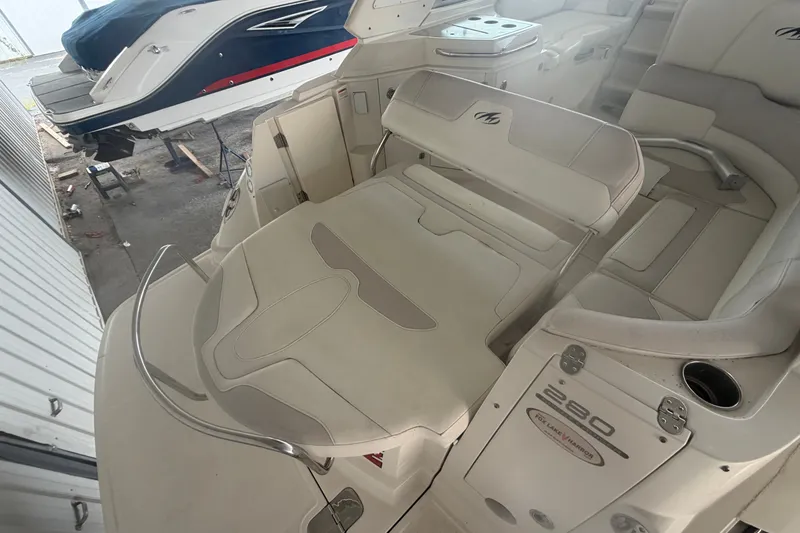 Slide: The Image of Interior view of a 2011 Monterey 280 SCR boat with beige seating and storage compartments. - 13