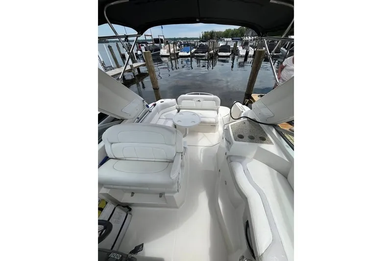 Slide: The Image of 2011 Monterey 280 SCR boat interior with white seating at a marina dock. - 26