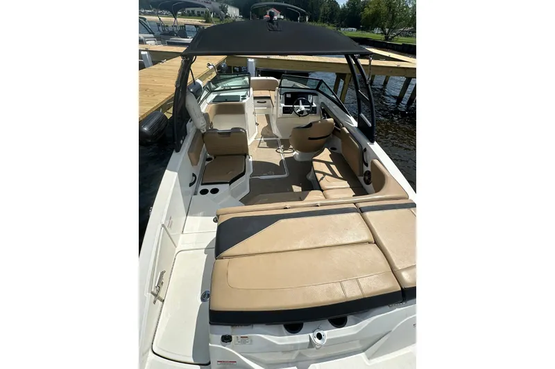 Slide: The Image of 2023 Sea Ray SPX 210 Outboard boat interior with tan seating and black canopy. - 6