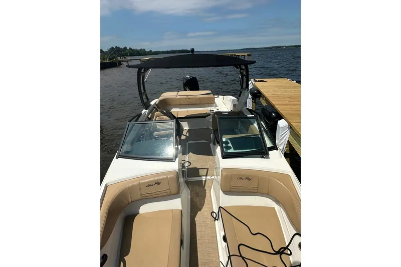 Slide: The Image of 2023 Sea Ray SPX 210 Outboard boat docked, featuring spacious seating and sleek design. - 10