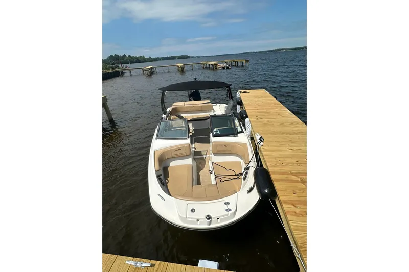 Slide: The Image of 2023 Sea Ray SPX 210 Outboard boat docked on a sunny day. - 2