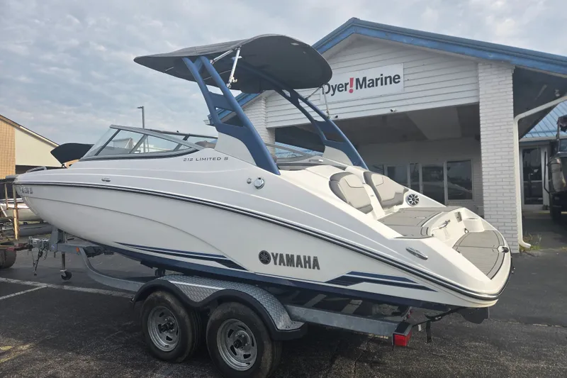 Slide: The Image of 2018 Yamaha Boats 212 Limited S on trailer outside marine dealership. - 1