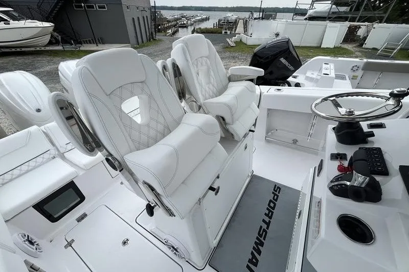 Slide: The Image of 2027 Sportsman Heritage 261 Center Console boat interior with white seating and steering wheel. - 7