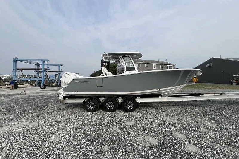 Slide: The Image of 2027 Sportsman Heritage 261 Center Console boat on trailer in a marina setting. - 1