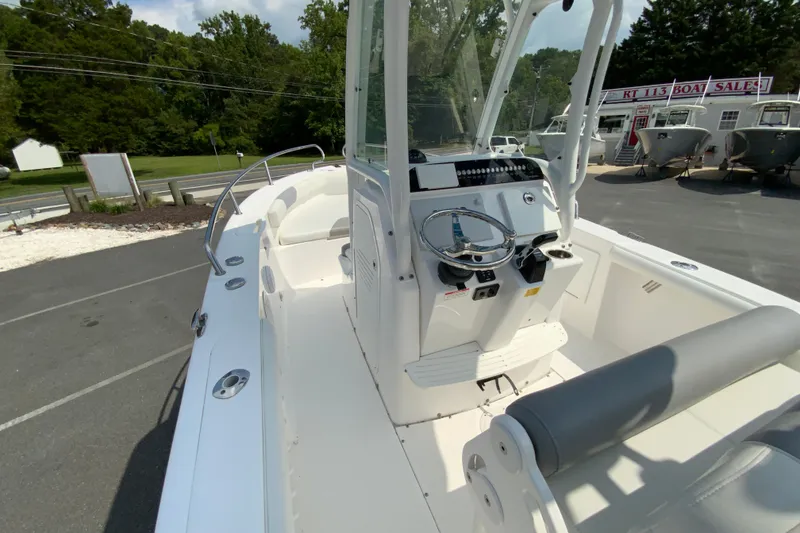 Slide: The Image of 2016 Everglades 230 Center Console boat with sleek design, parked at a dealership. - 19