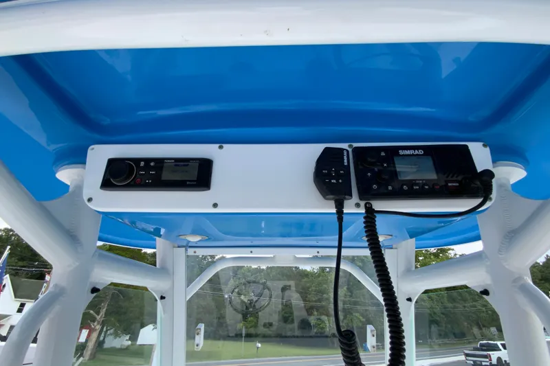 Slide: The Image of 2016 Everglades 230 Center Console boat with blue canopy and radio equipment. - 14