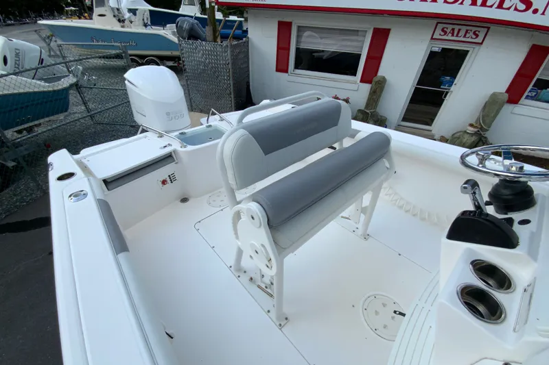 Slide: The Image of 2016 Everglades 230 Center Console boat interior with seating and controls, displayed at a sales location. - 15