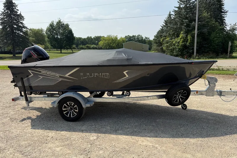 Slide: The Image of 2027 Lund 1800 Adventure SS boat on trailer, covered, parked outdoors. - 12
