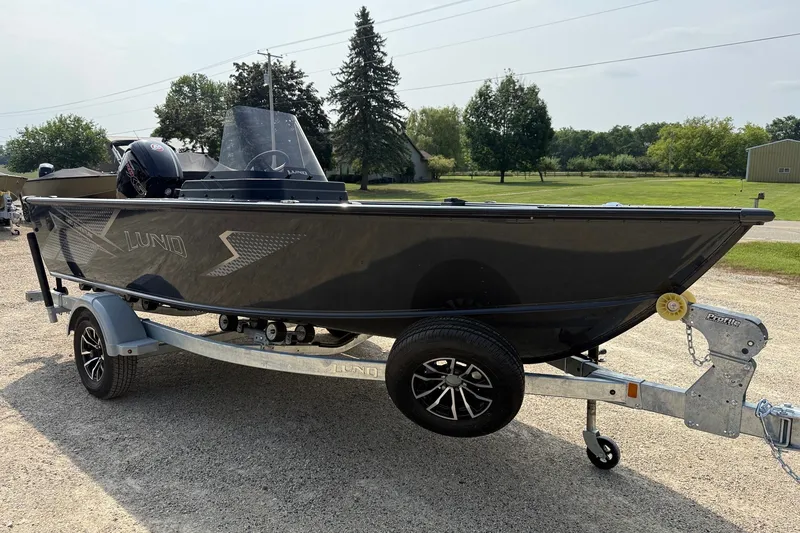 Slide: The Image of 2027 Lund 1800 Adventure SS boat on trailer, parked outdoors. - 2