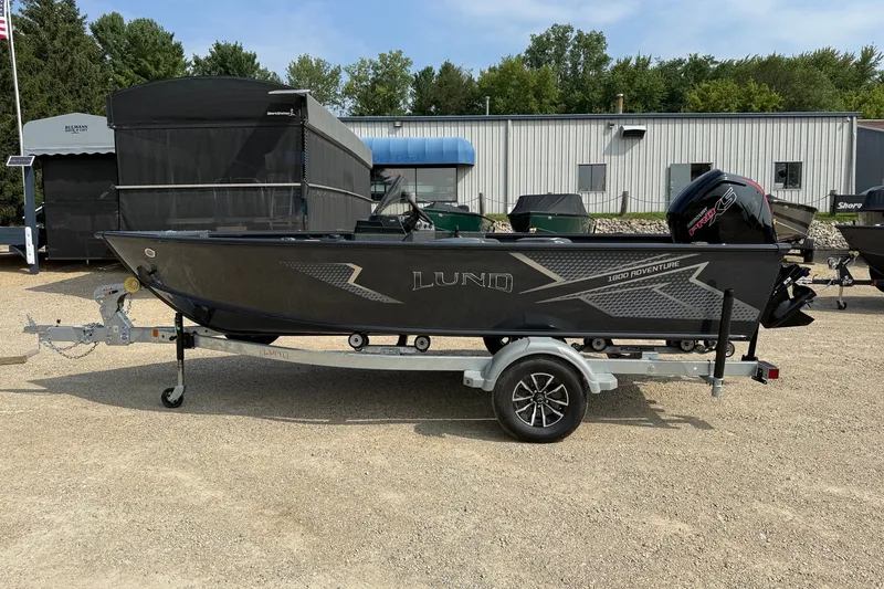 The Image of 2027 Lund 1800 Adventure SS boat on trailer, parked outdoors. - 1