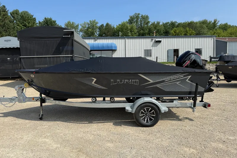 Slide: The Image of 2027 Lund 1800 Adventure SS boat on trailer, covered, parked outdoors. - 13