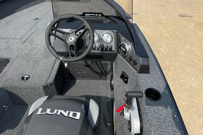 Slide: The Image of 2027 Lund 1800 Adventure SS boat interior with steering wheel and dashboard controls. - 7