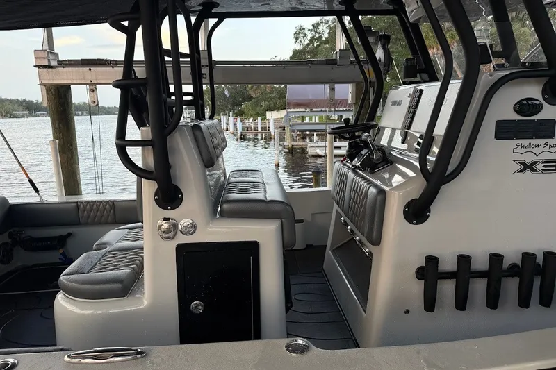 Slide: The Image of 2025 Shallow Sport 32 X3 boat interior with seating and control panel, dockside view. - 5