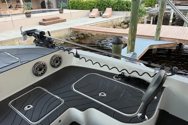 Slide: The Image of Shallow Sport 32 X3 boat interior, featuring speakers and a trolling motor, docked by a waterfront. - 13