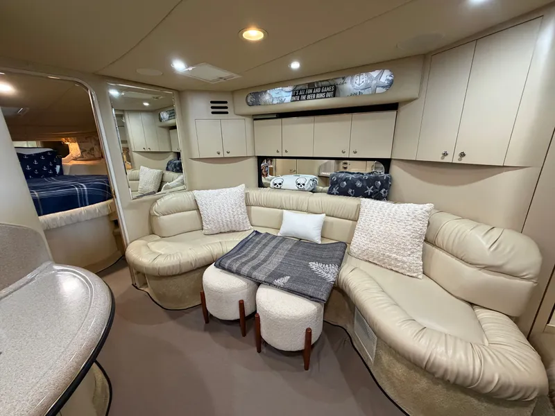 Slide: The Image of The interior of a 1999 Sea Ray 380 Sundancer features a cozy seating area with beige upholstery. - 15
